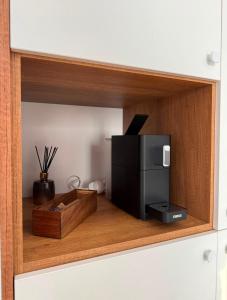 a cabinet with a microwave and a tv in it at Luca Rooms in Curtea de Argeş +3 photos