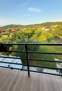 a balcony with a bench and a view of a yard at Luca Rooms in Curtea de Argeş