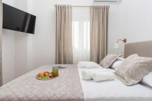 a bed with a plate of fruit and a drink on it at Villa Sky Stone, Heated Pool, Playground in Krstatice +53 photos