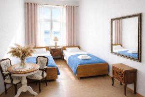 ein Schlafzimmer mit zwei Betten, einem Tisch und einem Spiegel in der Unterkunft Sentane in Swiętajno