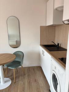 a kitchen with a table and a chair and a sink at Studio 7 in Fos-sur-Mer