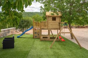 a playground with a play house and a swing at Villa Sky Stone, Heated Pool, Playground in Krstatice