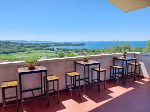 a row of tables and stools on a balcony at B&B Tramonti sull'Adriatico in Muggia