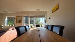 a dining room with a wooden table and chairs at Húsavík Apartment in Húsavík