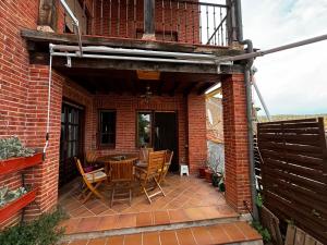 a patio with a table and chairs on a brick building at Casa Nectarius in Cifuentes