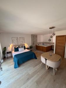 a bedroom with a bed and a tub and a table at Suite Canne Or in Bommes