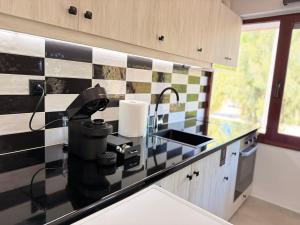 a kitchen with black and white tile on the counter at Electra Chios apartment in Chios +6 photos