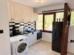 a kitchen with a washing machine and a refrigerator at Electra Chios apartment in Chios