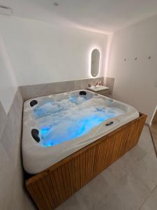 a large bath tub with blue water in a room at Suite Canne Or in Bommes +13 photos