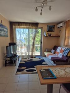 a living room with a couch and a tv at Apartmani Bozenov in Petrovac na Moru