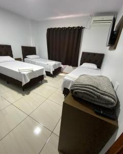 a room with two beds in a room at Hotel Villa Real in Pôrto Britânia