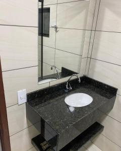 a bathroom with a sink and a mirror at Hotel Villa Real in Pôrto Britânia