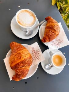 a table with two plates of croissants and a cup of coffee at B&b i Parenti in Palmi