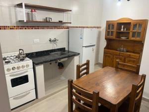 a kitchen with a table and a white stove top oven at Espacio493 in Villa Gesell