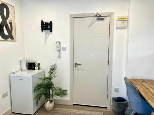 a white door in a room with a refrigerator at Sutton & Stone in Sutton