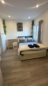 a bedroom with a large bed and a wooden floor at Sutton & Stone in Sutton
