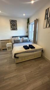 a bedroom with a bed and a wooden floor at Sutton & Stone in Sutton