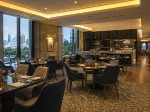 a restaurant with tables and chairs and a bar at Hotel Tela Suite Near IGI Airport Delhi in New Delhi