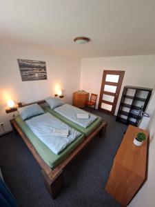 a bedroom with a large bed and a table at Apartmán Žižka in Frymburk
