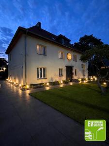 a building with lights in a yard at night at Stay Adventure Mrzeżyno in Mrzeżyno
