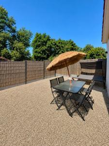 a table and two chairs with an umbrella at Suite Canne Or in Bommes