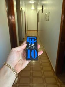 a person holding up a piece of paper at Hotel em Caçu in Caçu