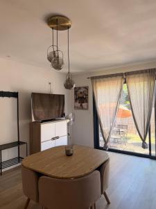 a dining room with a table and a large window at Suite Canne Or in Bommes