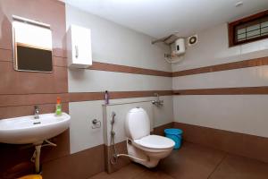 a bathroom with a toilet and a sink at MeadowView Cottage Marari in Mararikulam +22 photos
