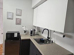 a small kitchen with a sink and a microwave at Where Comfort Meets Cozy Vibes in Montreal +18 photos