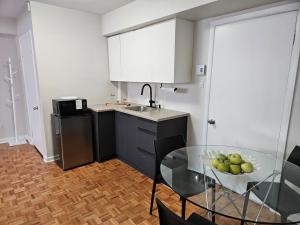 a kitchen with a glass table with a bowl of apples on it at Where Comfort Meets Cozy Vibes in Montreal