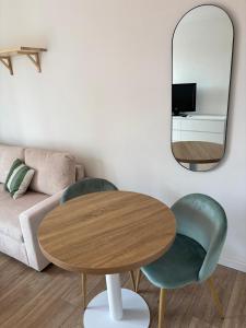 a living room with a table and two chairs and a mirror at Studio 7 in Fos-sur-Mer