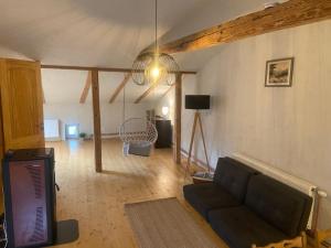 a living room with a couch and a tv at Cesis city apartment in Cēsis