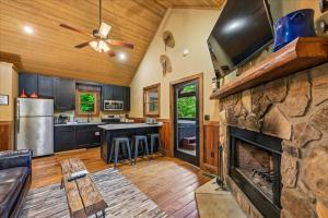 a kitchen with a stone fireplace and a stove at Summit View by Venture Smoky Mountains in Sevierville