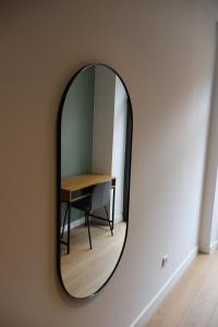 a mirror on a wall with a table and a chair at MoV Flexliving in Oviedo