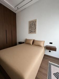 a bedroom with a large bed and a painting on the wall at A Suites in Casablanca