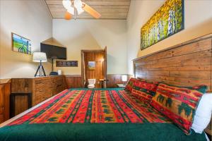 a bedroom with a large bed with a wooden headboard at Summit View by Venture Smoky Mountains in Sevierville +40 photos