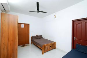 a small bedroom with a bed and a door at MeadowView Cottage Marari in Mararikulam
