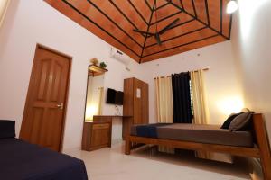 a bedroom with a bed and a wooden ceiling at MeadowView Cottage Marari in Mararikulam