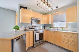 a kitchen with wooden cabinets and stainless steel appliances at Lake Life Landing in Sylvan Lake