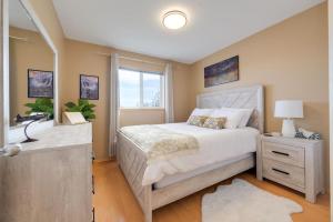 a bedroom with a white bed and a window at Lake Life Landing in Sylvan Lake