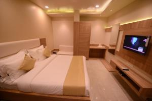a bedroom with a large bed and a flat screen tv at Silver Pride Boutique Hotel in Jaipur