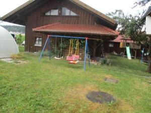 a yard with swings in front of a house at Haus Franz in Zandt