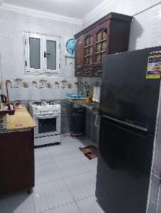 a kitchen with a stove and a refrigerator at شقة سوبر لوكس ثلاث غرف بعين شمس الشرقية in Cairo