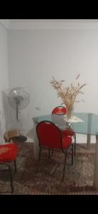 a table with two chairs and a table with a vase at شقة سوبر لوكس ثلاث غرف بعين شمس الشرقية in Cairo