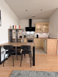 a kitchen with a wooden table and black chairs at Apartment am Kalsmunt in Wetzlar