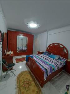 a bedroom with a bed and a mirror and a chair at شقة سوبر لوكس ثلاث غرف بعين شمس الشرقية in Cairo +4 photos