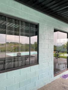 a brick building with glass windows on the side of it at Espaço Mattigor, Chácara mil m2, piscina grande com prainha e vista deslumbrante in Caçapava +8 photos