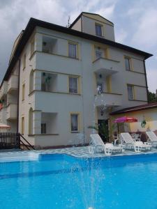 un edificio con piscina frente a un edificio en Hotel Bellevue en Doksy