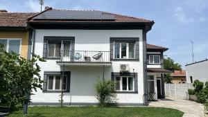 a white house with a balcony on top of it at Moon Stylish -FREE parking -Romantic City Stay in Timişoara