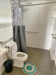 a bathroom with a toilet and a shower and a sink at Espaço Mattigor, Chácara mil m2, piscina grande com prainha e vista deslumbrante in Caçapava